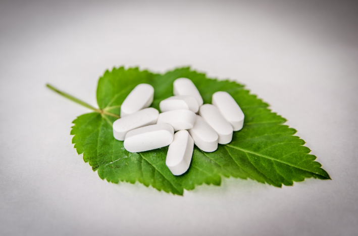 white pills on a green leaves